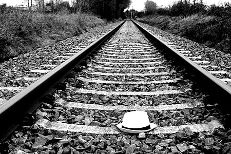 grayscale photo of hat on railway thumbnail