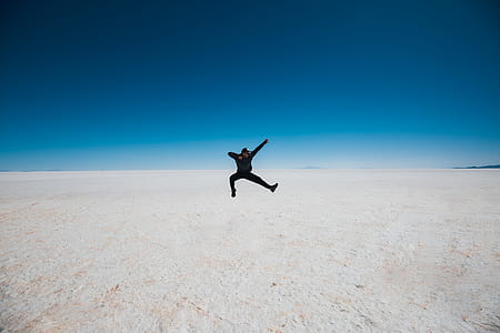 man jumping on white surface during daytime thumbnail