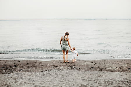 woman holding child at beach side thumbnail
