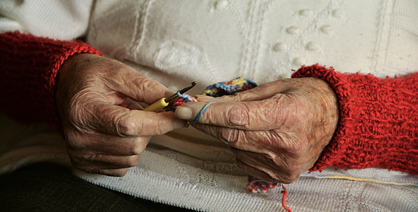 person wearing white and red sweater and knitting thumbnail