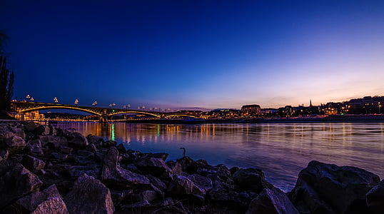 bridge near skyscrapers during sunset thumbnail