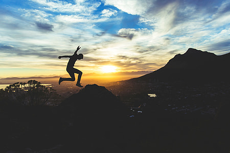 silhouette of a person jumping on mountain thumbnail