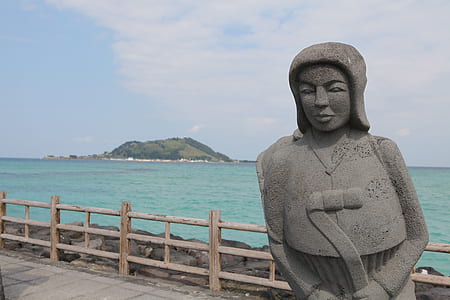 gray stone woman statue near brown wooden fence thumbnail
