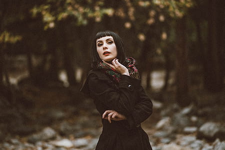 woman in black coat in the middle of the forest thumbnail