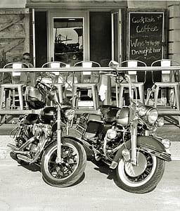 two cruiser motorcycles parked in front of cafe thumbnail