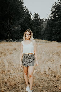 woman standing surrounded by brown grass and trees outdoor thumbnail