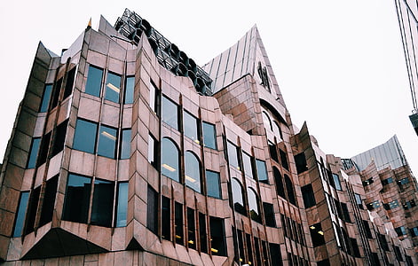 brown concrete building under cloudy sky thumbnail