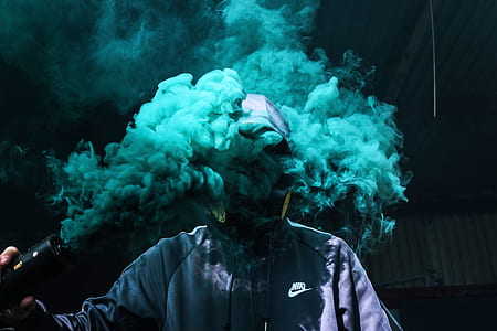 man blowing blue smoke on his head thumbnail