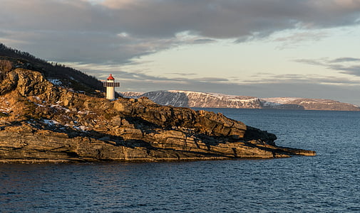 lighthouse on brown rocky mountain thumbnail