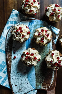 six cupcake with pomegranate toppings on brown tabletop thumbnail