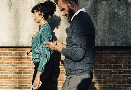 man and woman walking on sidewalk near wall thumbnail