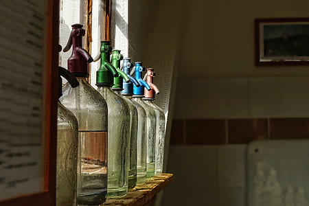 bottles on wooden shelf near window thumbnail