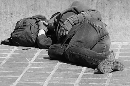 grayscale photography of man wearing jacket near bag thumbnail