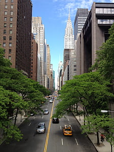 several cars in between high rise buildings thumbnail