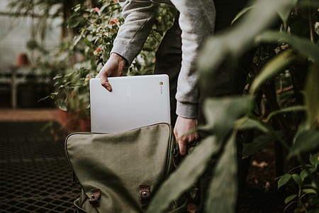 person holding Acer Chromebook laptop on an opened gray bag inside building with flowers thumbnail