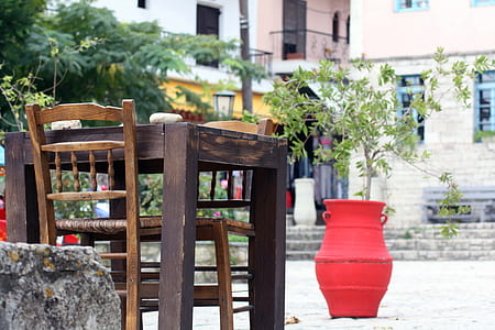 empty brown wooden chairs beside tables during daytime thumbnail