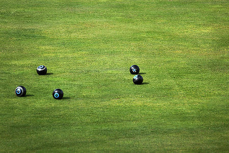 five black balls on green grass field thumbnail