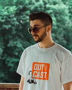 selective focus photo of man wears white Out Cast crew-neck t-shirt thumbnail