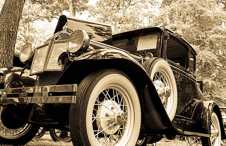 sephia photo of vintage vehicle near trees thumbnail
