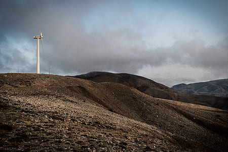 white wind turbine on top of hill thumbnail
