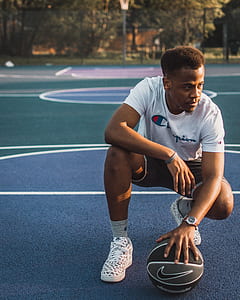 man holding basketball on basketball court at daytime thumbnail