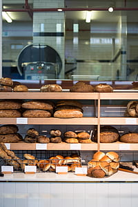 bunch of baked breads on wooden shelf thumbnail