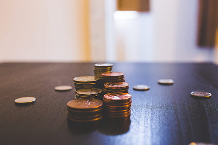 stacked round copper-colored coins on brown plank thumbnail