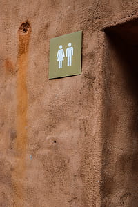 male and female signage mounted on brown concrete wall thumbnail
