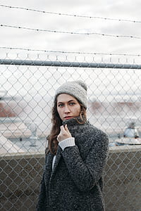woman standing near gray wire fence thumbnail