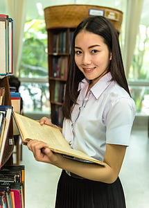woman in whiteblouse and black shirt holding book thumbnail