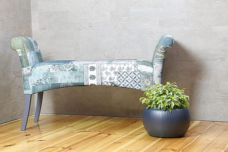 gray and white floral stool beside blac potted green leaf plant thumbnail
