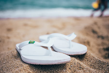 White slippers on sand on the beach with blurred background thumbnail