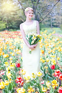 photograph of woman wearing yellow dress on a bed of flowers thumbnail