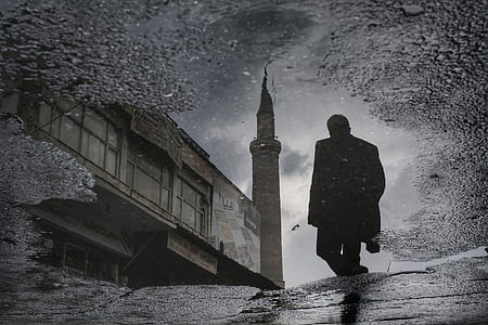 man walking through gray concrete tower thumbnail
