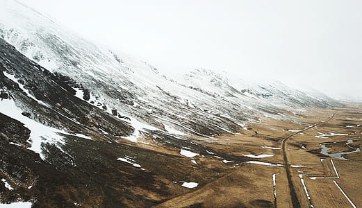 snow covered mountains with brown fields thumbnail