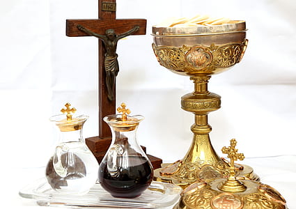 brown wooden crucifix beside a two glass containers and gold goblet thumbnail