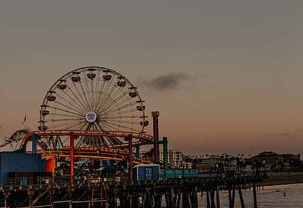 amusement park on brown wooden pier during sunset thumbnail