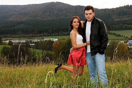 woman and man standing beside each other on grass field at daytime thumbnail