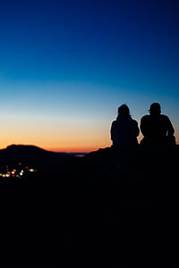 silhouette photo of two person under blue sky during golden hour thumbnail