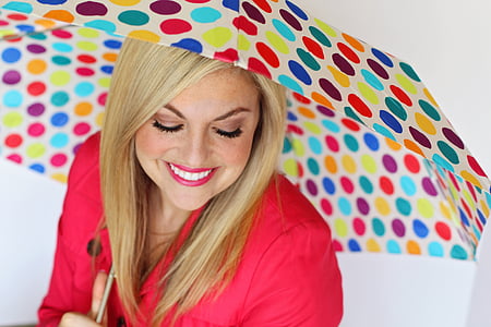 smiling woman while holding umbrella thumbnail