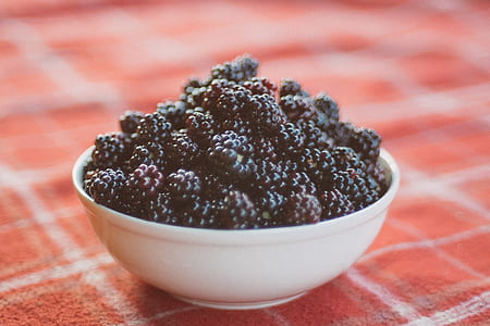 red and black berries in white ceramic bowl thumbnail