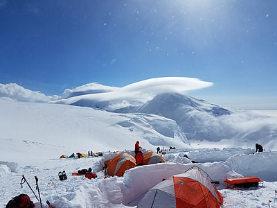 campers on mountain with snow under clear blue sky thumbnail