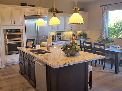 grey kitchen island with three beige pendant lamps turned on thumbnail