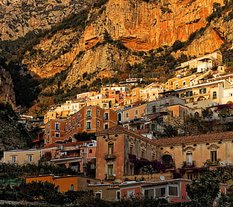 brown concrete houses near mountain at daytime thumbnail