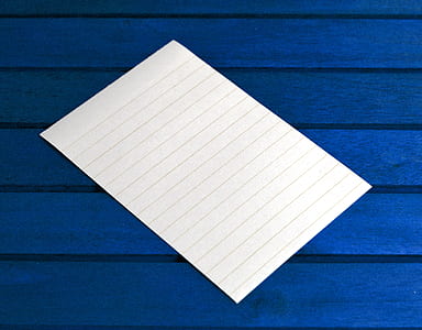 empty white lined paper on blue surface thumbnail