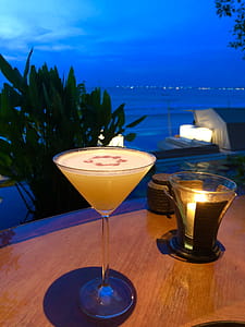 Orange Liquid in Clear Martini Glass on Brown Wooden Surface thumbnail