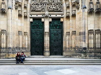 man and woman sitting beside black gate thumbnail