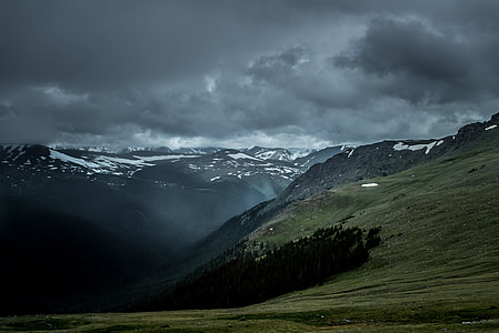 mountain cliff covered with fog under cloudy sky thumbnail