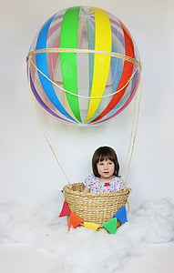 girl with multicolored shirt on brown wicker hot air balloon thumbnail