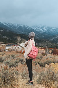 woman wearing white jacket and gray hat watching the mountain thumbnail